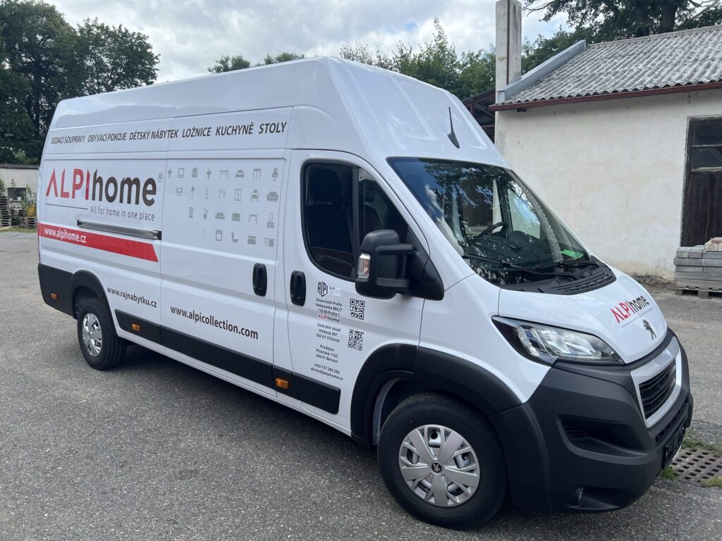 Bílá dodávka Peugeot Boxer ALPIhome s polepem, logem a sortimentem nábytku