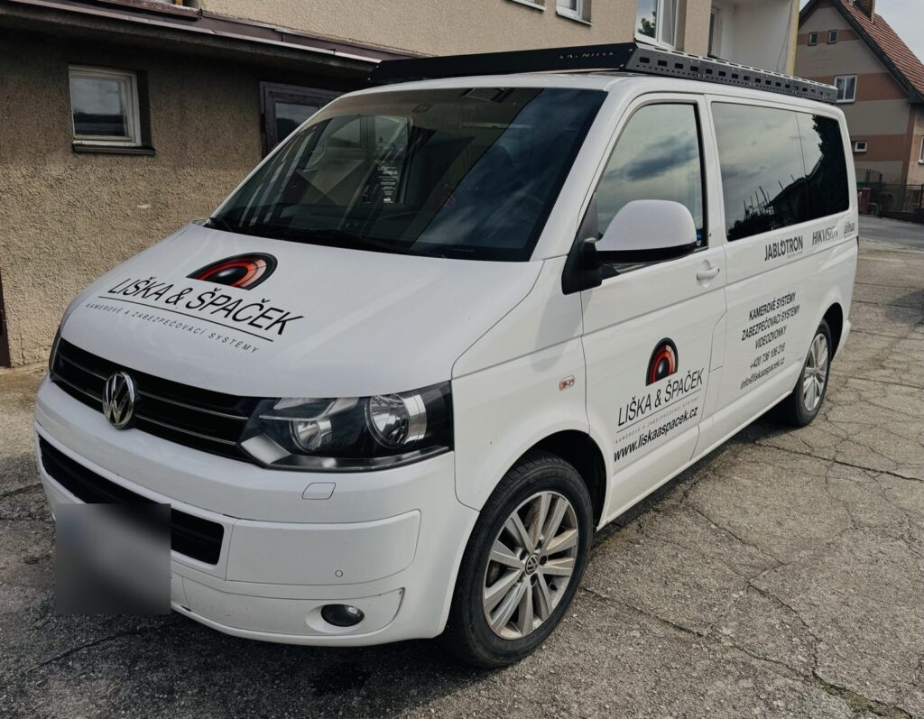 Bílá dodávka Volkswagen Transporter Liška & Špaček s polepem na kapotě a bocích